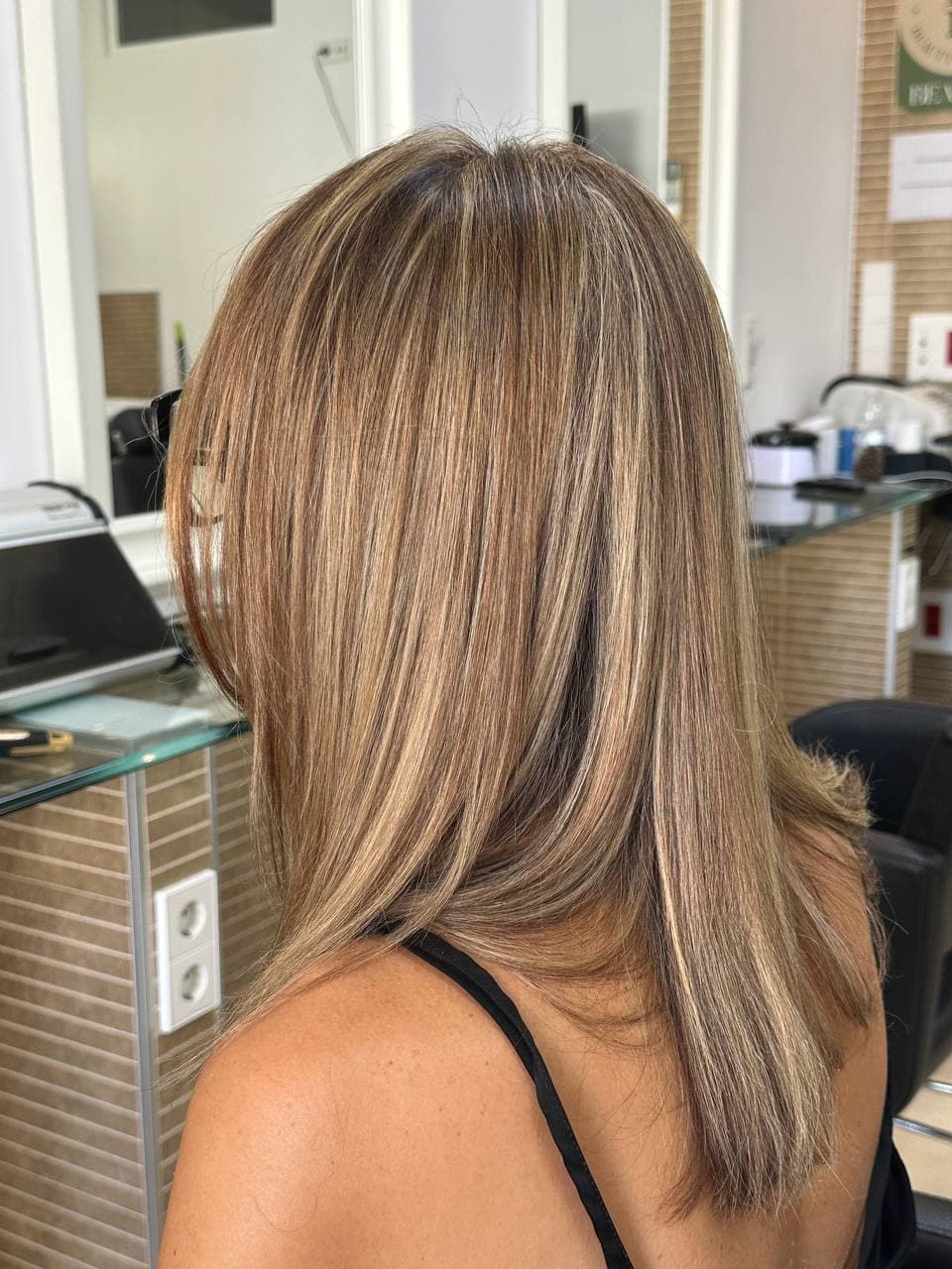 Sleek, evenly maintained balayage colour on medium-length hair in Marbella