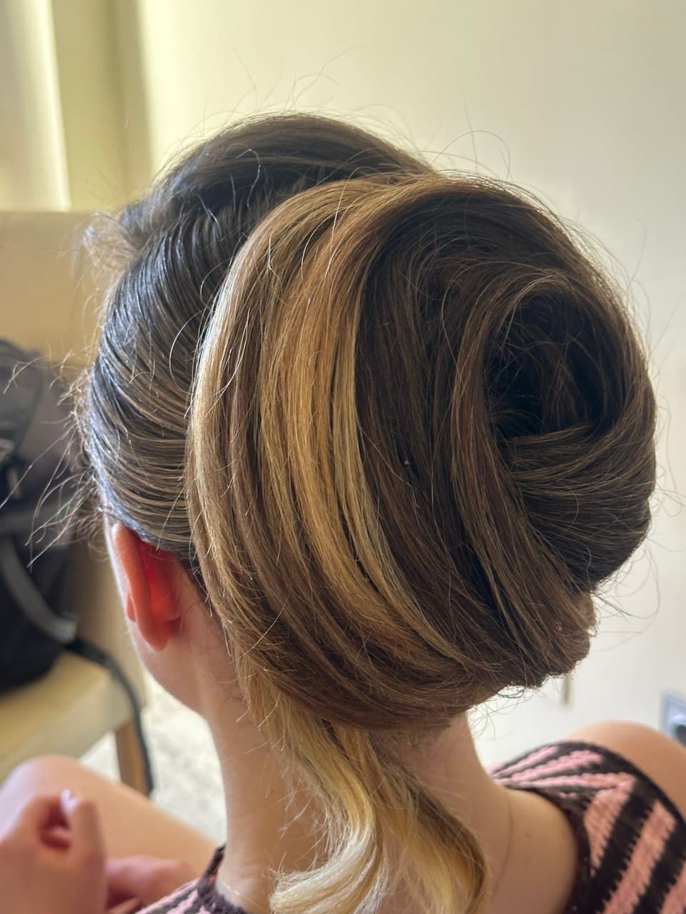 Polished low bun styled on-location for a special event in Marbella