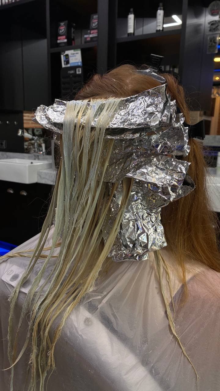 Foils applied to lift orange hair in controlled stages during a colour correction