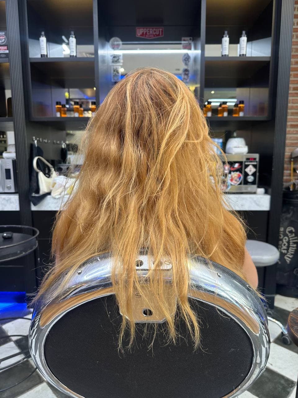 Orange, uneven and dry hair before colour correction, seen from the back
